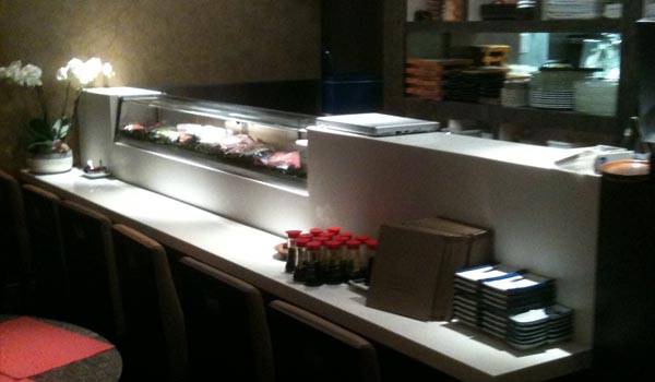 <b>ORIENT EXTREME</b> - 4, rue Bernard Palissy - Paris VIe<br/><br/>Restaurant japonais, cuisine semi-ouverte et sushibar en Corian.<br/>La vitrine à sushi est une vitrine standard intégrée à un linéaire sur mesure.